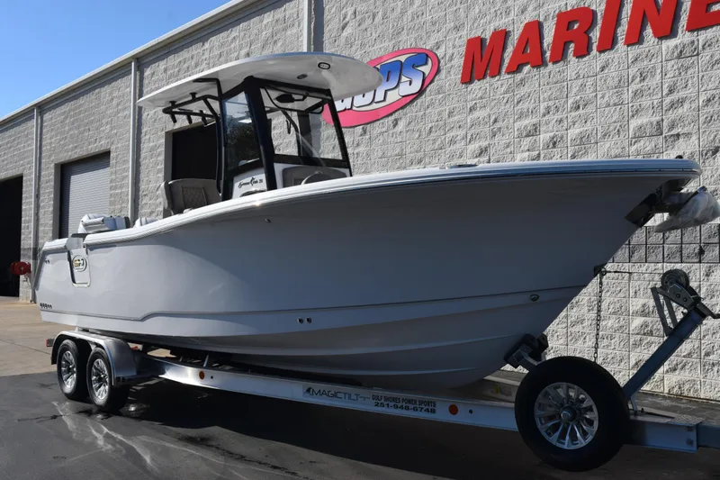 Slide: The Image of 2026 Sea Hunt Gamefish 25 boat on trailer outside marine dealership. - 2