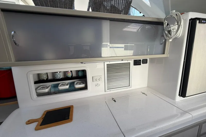 Slide: The Image of Modern kitchen area in 2022 Seawind 1160 Lite catamaran with storage and appliances. - 12
