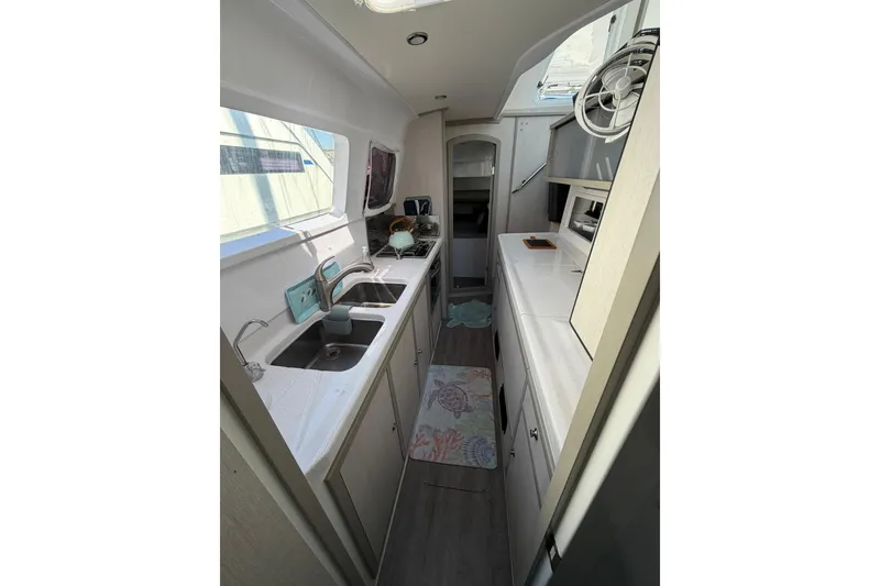 Slide: The Image of Interior of 2022 Seawind 1160 Lite yacht, featuring modern kitchen with dual sinks. - 16