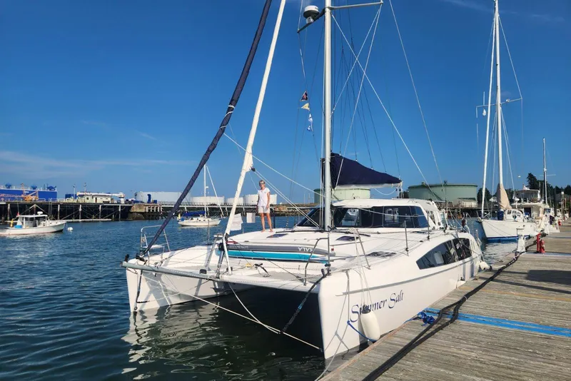 Slide: The Image of 2022 Seawind 1160 Lite catamaran docked at marina with clear blue sky. - 2
