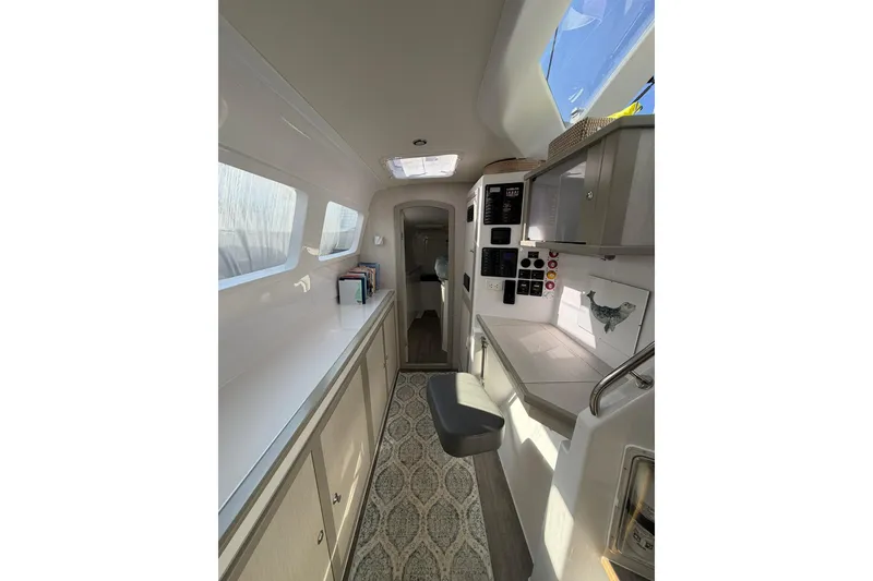 Slide: The Image of Interior of 2022 Seawind 1160 Lite catamaran, featuring modern cabinetry and control panels. - 24
