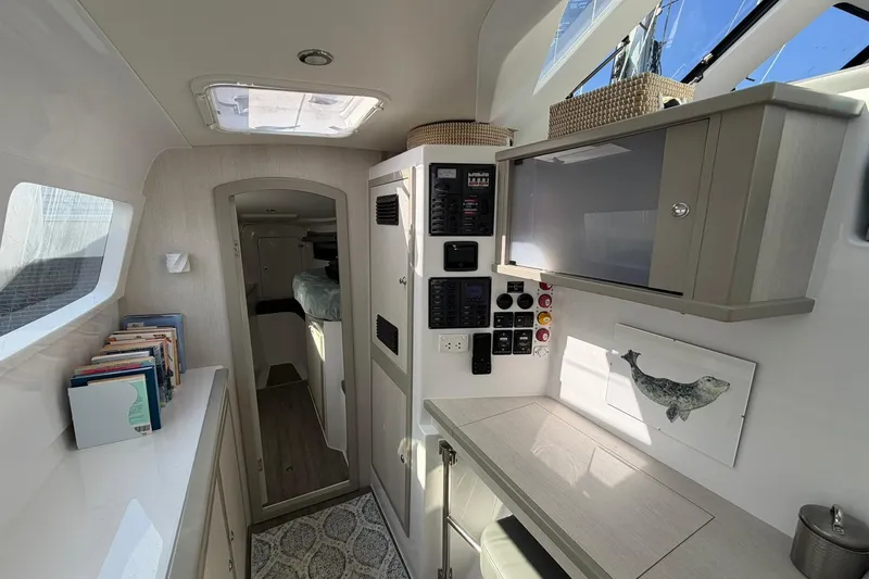 Slide: The Image of Interior of 2022 Seawind 1160 Lite catamaran, featuring modern cabinetry and control panels. - 25
