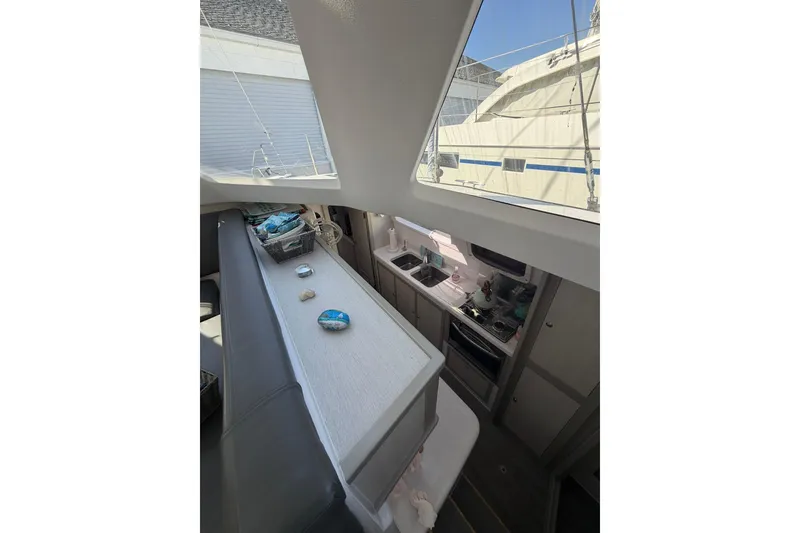 Slide: The Image of Interior view of 2022 Seawind 1160 Lite catamaran with modern kitchen and seating area. - 27