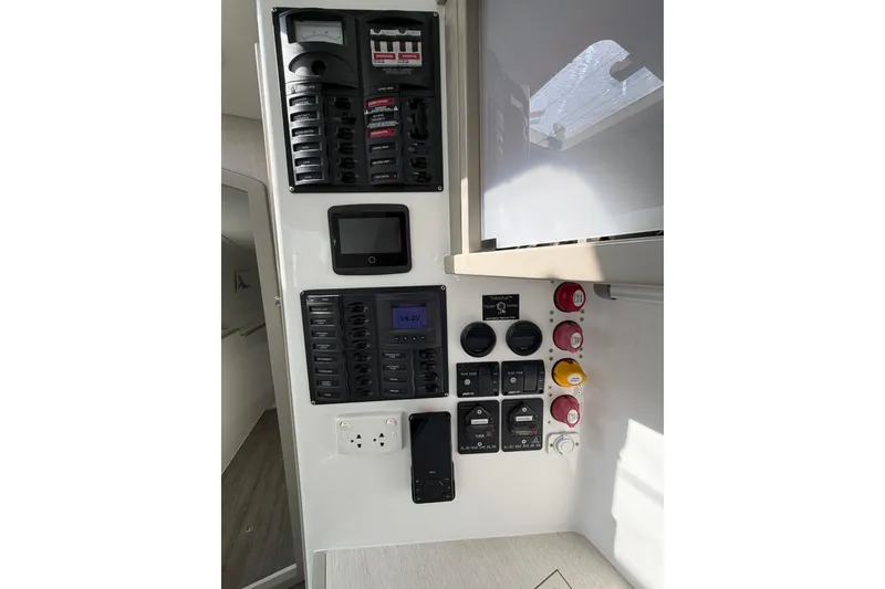 Slide: The Image of Control panel of 2022 Seawind 1160 Lite with Diesel Motors, featuring switches and gauges. - 28