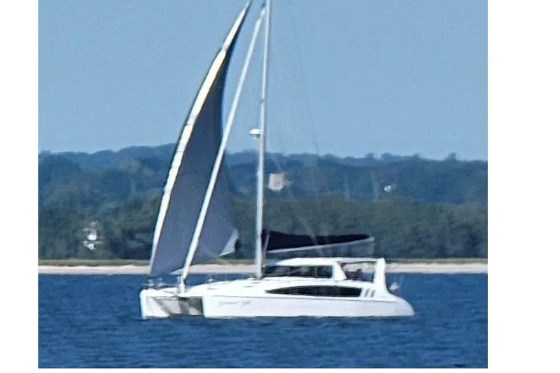 Slide: The Image of 2022 Seawind 1160 Lite catamaran sailing on a calm blue sea. - 5