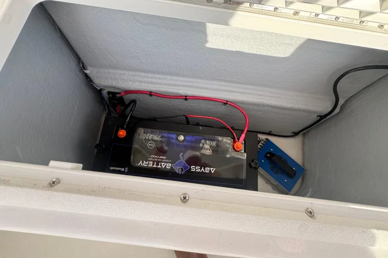 Slide: The Image of Battery compartment of 2023 Sea Hunt Ultra 305 SE boat with wiring and components. - 12