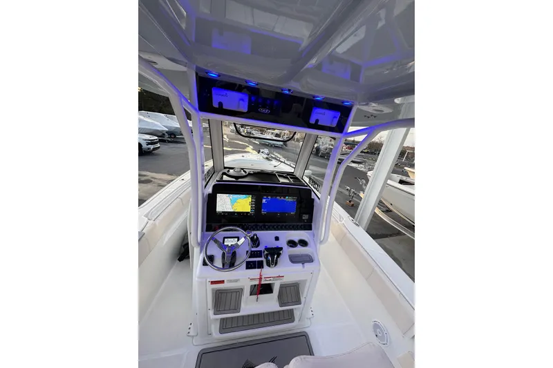 Slide: The Image of 2023 Sea Hunt Ultra 305 SE boat cockpit with advanced navigation system and illuminated controls. - 2