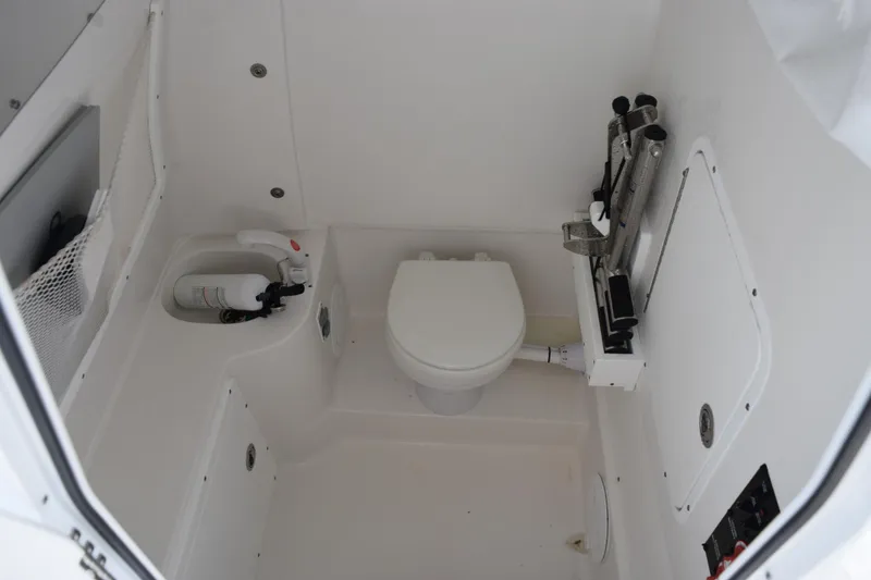 Slide: The Image of 2023 Sea Hunt Ultra 305 SE boat interior with toilet and safety equipment. - 22