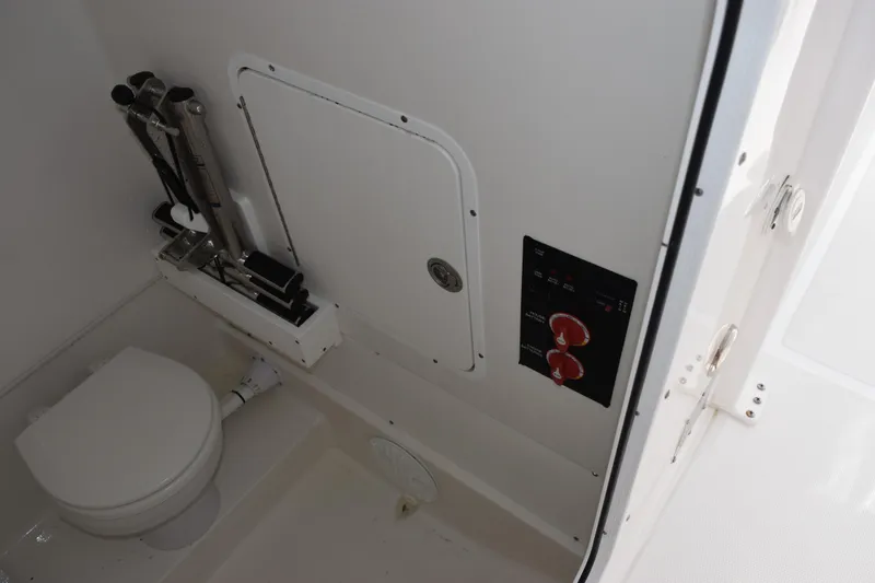 Slide: The Image of 2023 Sea Hunt Ultra 305 SE boat interior with toilet and control panel. - 24