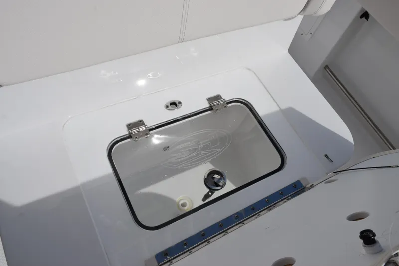 Slide: The Image of 2023 Sea Hunt Ultra 305 SE boat storage compartment with transparent lid. - 26