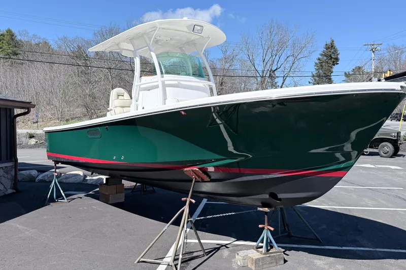 Slide: The Image of 2008 Hunt Yachts Surfhunter 25 Center Console on stands, green hull, outdoor setting. - 12