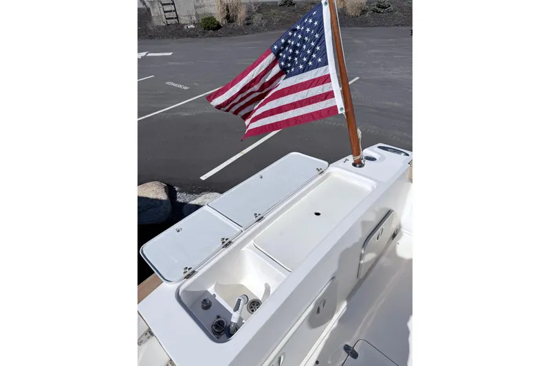 Slide: The Image of 2008 Hunt Yachts Surfhunter 25 Center Console with American flag, docked in parking area. - 15
