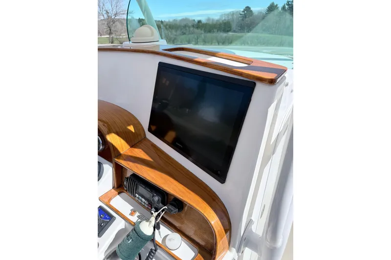 Slide: The Image of 2008 Hunt Yachts Surfhunter 25 Center Console dashboard with wood accents and navigation screen. - 18