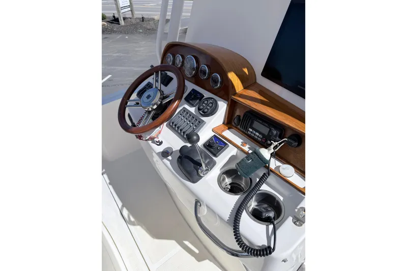 Slide: The Image of 2008 Hunt Yachts Surfhunter 25 Center Console helm with wooden steering wheel and controls. - 19
