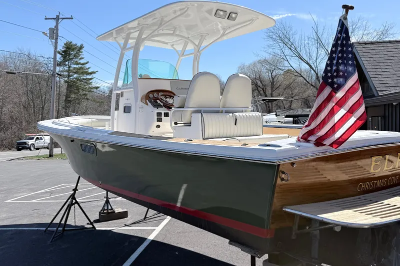Slide: The Image of 2008 Hunt Yachts Surfhunter 25 Center Console with American flag, parked outdoors. - 6