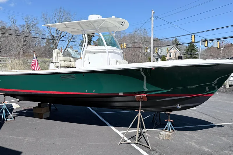 Slide: The Image of 2008 Hunt Yachts Surfhunter 25 Center Console boat on stands, green hull, outdoor setting. - 9