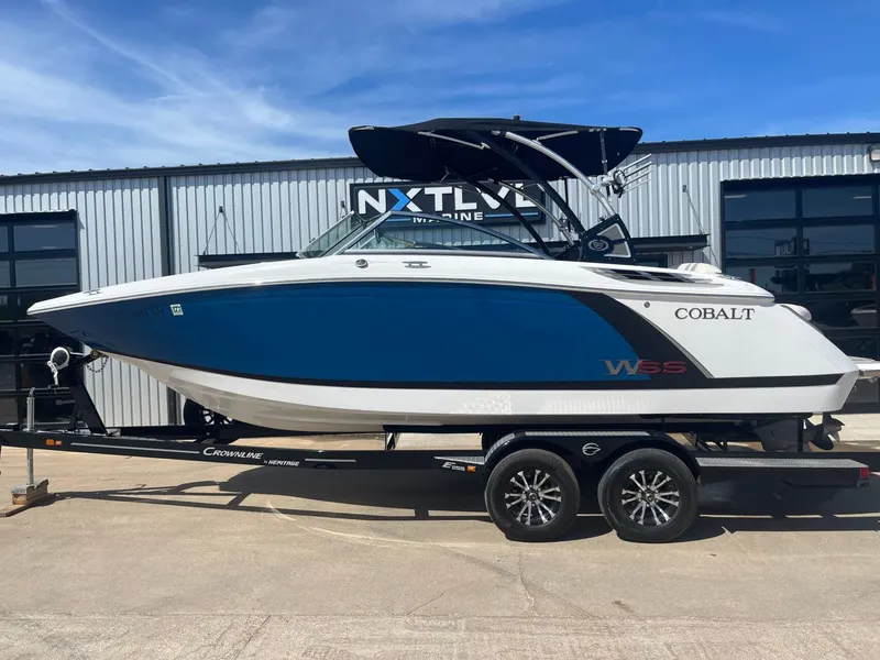 The Image of 2016 Cobalt 24SD boat on trailer in front of building. - 1