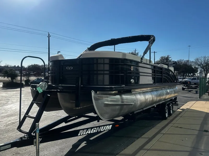 Slide: The Image of 2022 Harris Sunliner 250 pontoon boat on trailer in sunny setting. - 4