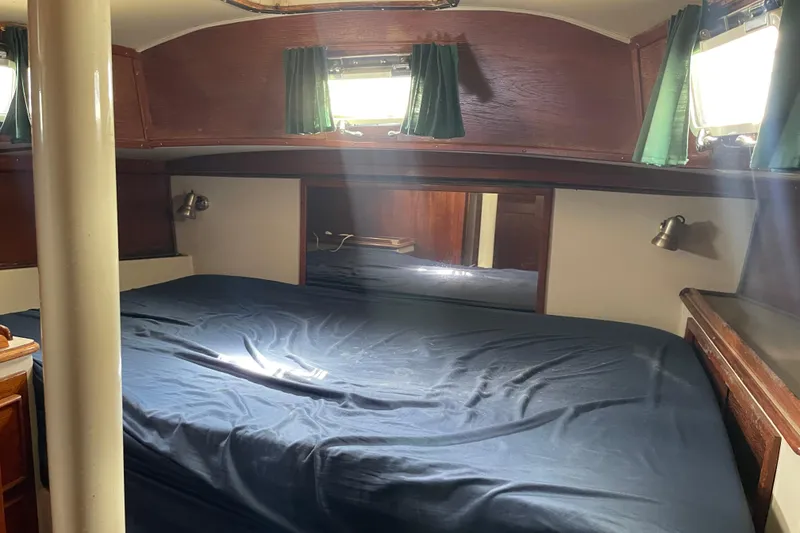 Slide: The Image of Cozy cabin interior of Irwin 37 Mk V sailboat with blue bedding and wooden accents. - 19