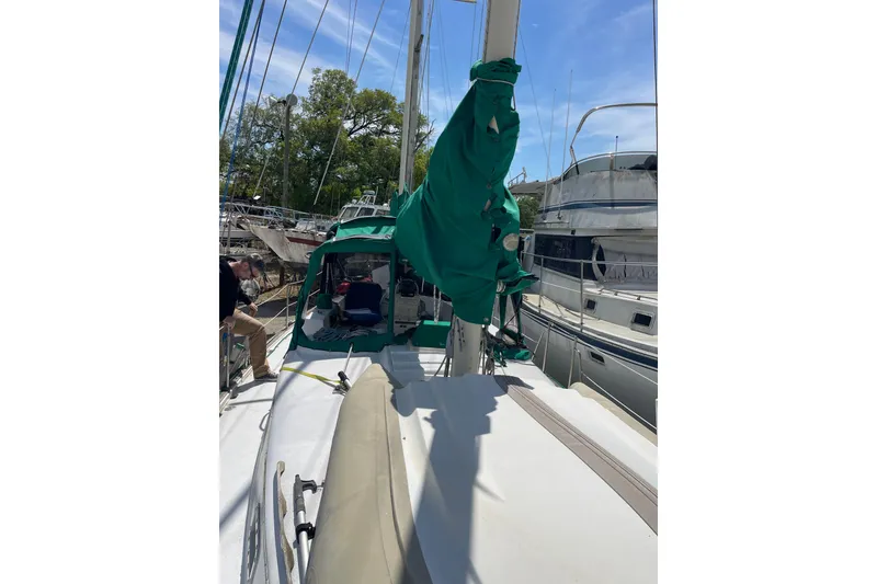 Slide: The Image of Sailboat Irwin 37 Mk V docked, featuring green sail cover and deck view. - 7