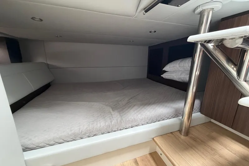 Slide: The Image of 2025 Formula 380 Super Sport Crossover OB cabin interior with bed and wooden steps. - 38