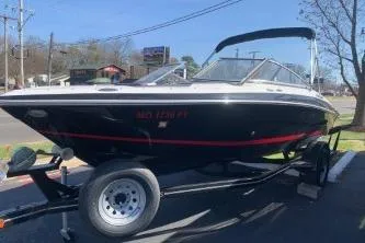 The Image of 2011 Four Winns H200 boat on trailer, parked outdoors under clear sky. - 0