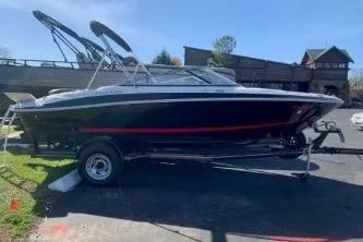 Slide: The Image of 2011 Four Winns H200 boat on trailer, parked outdoors under clear sky. - 1