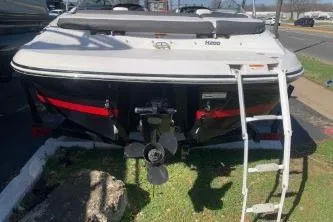 Slide: The Image of 2011 Four Winns H200 boat with ladder, parked on grass. - 3
