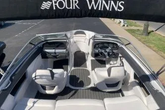 Slide: The Image of 2011 Four Winns H200 boat interior with seating and dashboard, under canopy. - 7
