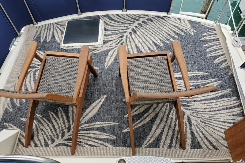 Slide: The Image of Two wooden chairs on a patterned rug aboard a 1986 Tollycraft 34 Sundeck. - 17