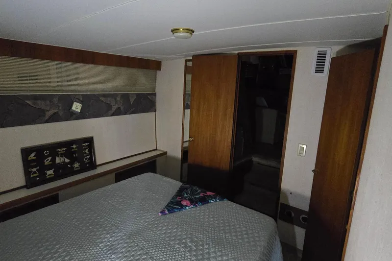 Slide: The Image of Interior cabin of 1986 Tollycraft 34 Sundeck with bed and wooden decor. - 24