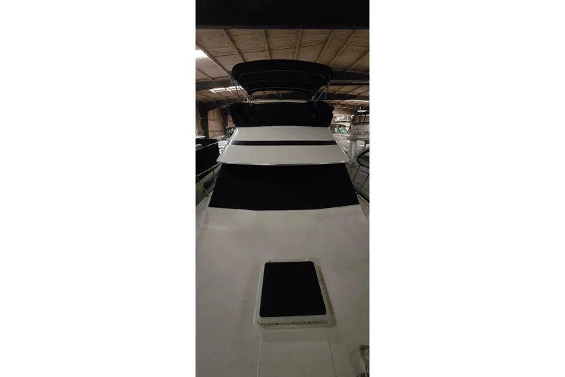 Slide: The Image of 1986 Tollycraft 34 Sundeck yacht in indoor storage, showcasing sleek design. - 3