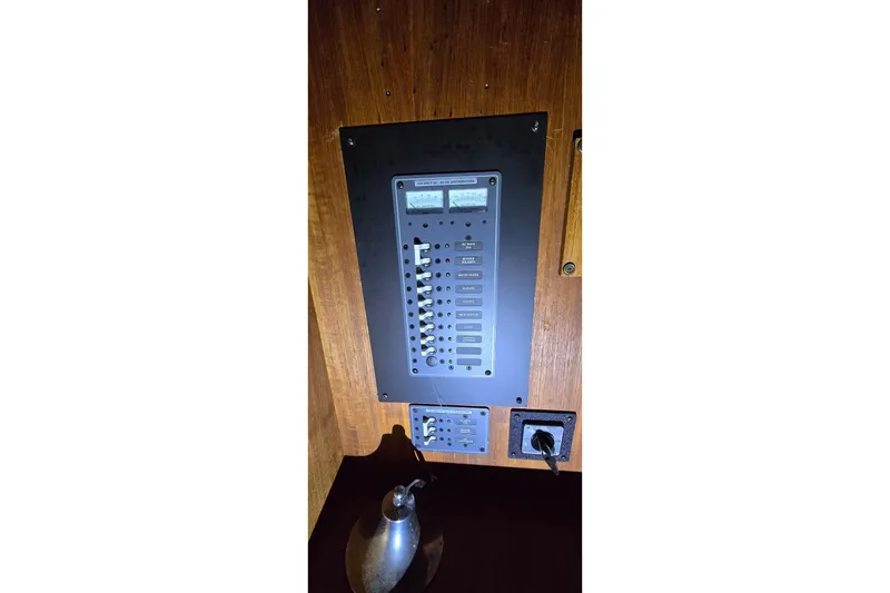 Slide: The Image of Electrical panel on 1986 Tollycraft 34 Sundeck boat, featuring switches and gauges. - 33
