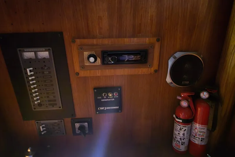 Slide: The Image of Control panel of 1986 Tollycraft 34 Sundeck with fire extinguishers and generator controls. - 34