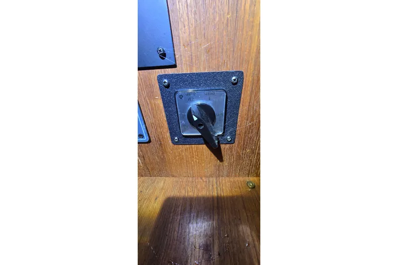 Slide: The Image of Switch panel on 1986 Tollycraft 34 Sundeck boat, mounted on wooden surface. - 36