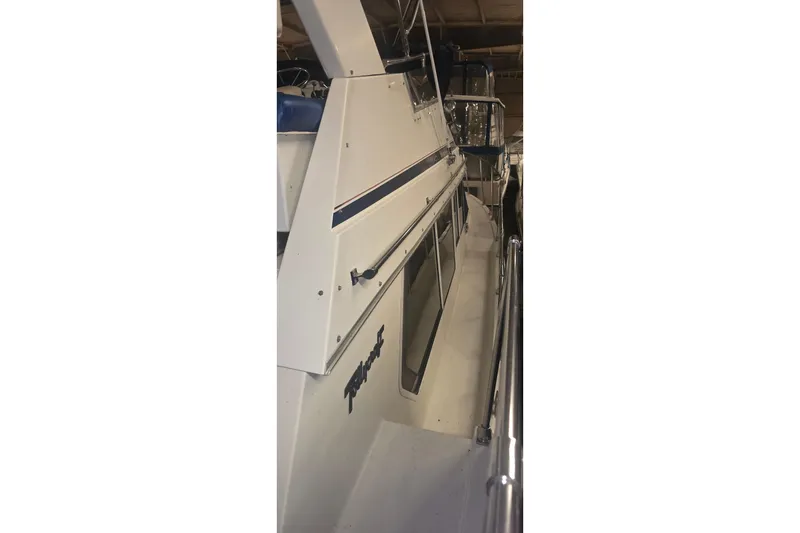 Slide: The Image of 1986 Tollycraft 34 Sundeck yacht side view in a marina setting. - 5