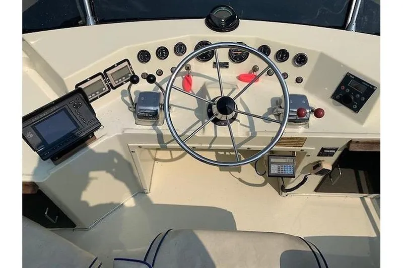 Slide: The Image of 1986 Tollycraft 34 Sundeck helm with steering wheel and navigation instruments. - 6