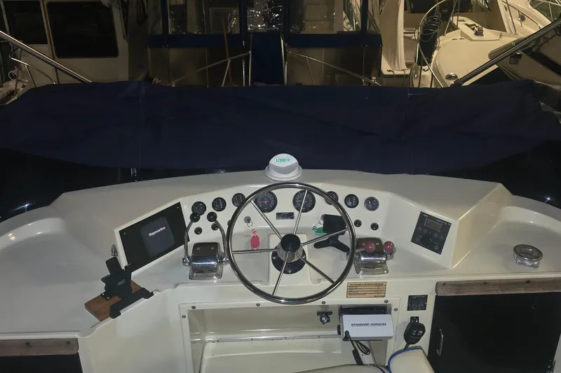 Slide: The Image of 1986 Tollycraft 34 Sundeck helm with steering wheel and navigation instruments. - 7