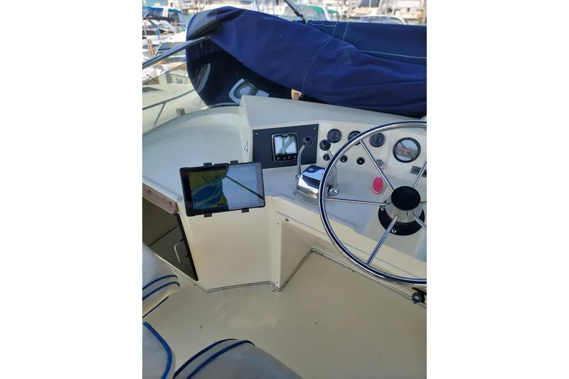 Slide: The Image of 1986 Tollycraft 34 Sundeck helm with steering wheel, gauges, and navigation equipment. - 8