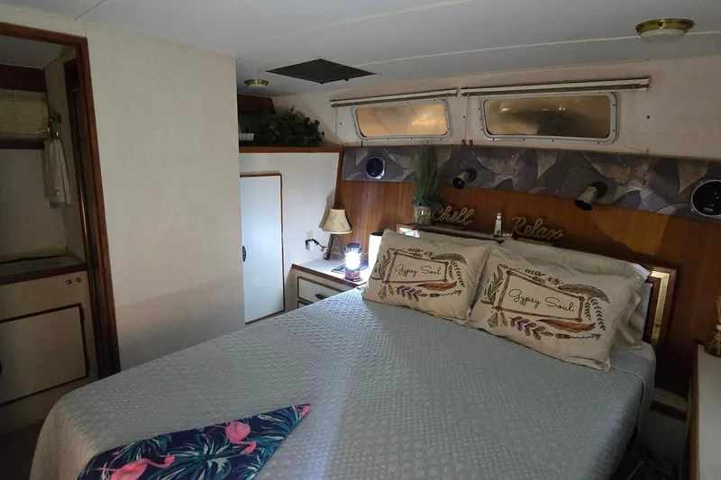 Slide: The Image of Cozy bedroom interior of 1986 Tollycraft 34 Sundeck with decorative pillows and ambient lighting. - 19