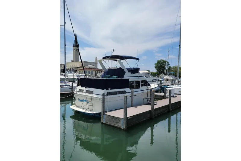 Slide: The Image of 1986 Tollycraft 34 Sundeck yacht docked at marina under blue sky. - 2