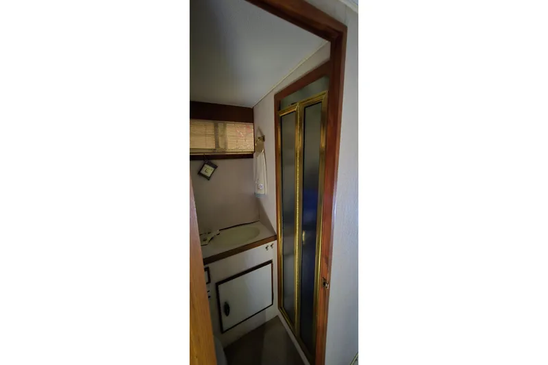 Slide: The Image of 1986 Tollycraft 34 Sundeck bathroom with sink, mirror, and shower door. - 21