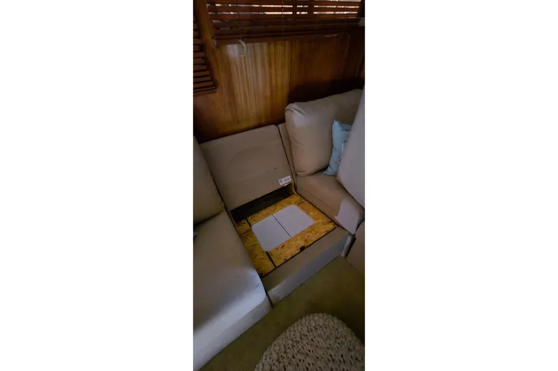 Slide: The Image of Interior of 1986 Tollycraft 34 Sundeck with open floor panel and beige seating. - 28
