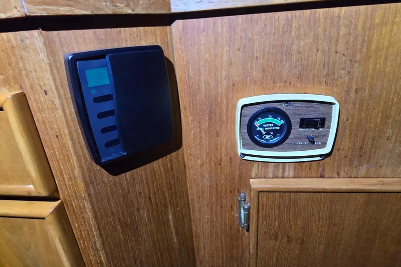 Slide: The Image of 1986 Tollycraft 34 Sundeck water level indicator and control panel on wooden surface. - 48