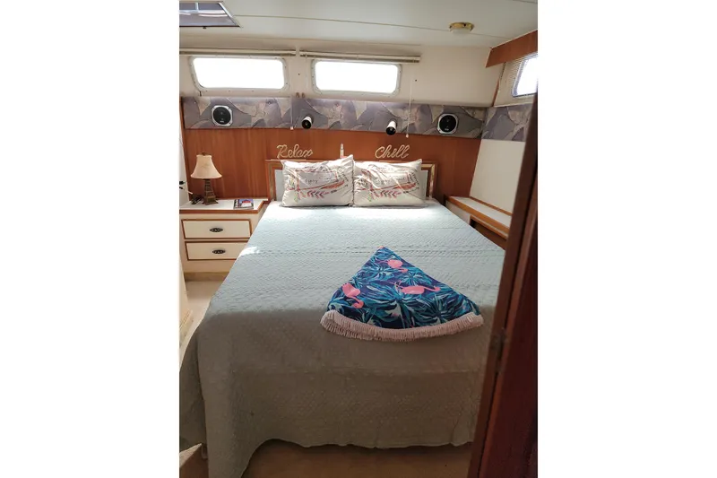 Slide: The Image of Cozy bedroom in 1986 Tollycraft 34 Sundeck yacht with decorative pillows and natural light. - 53