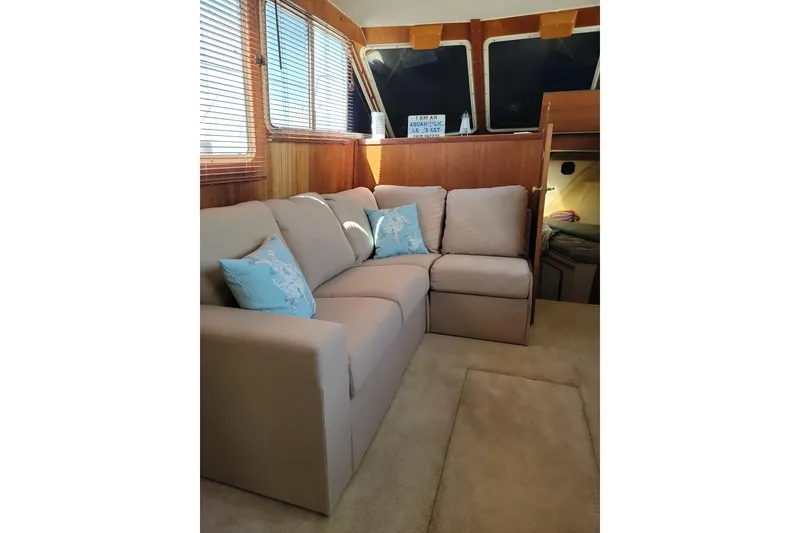 Slide: The Image of Interior of 1986 Tollycraft 34 Sundeck with beige sofa and nautical decor. - 54