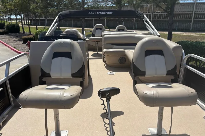 Slide: The Image of 2013 Sun Tracker Fishin' Barge 22 DLX with beige seating and steering console. - 4