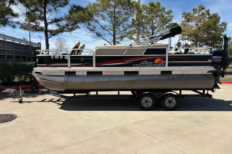 Slide: The Image of 2013 Sun Tracker Fishin' Barge 22 DLX pontoon boat on trailer, parked outdoors. - 7