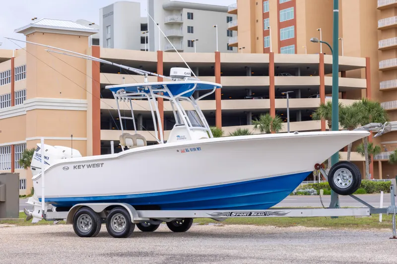 The Image of 2016 Key West 244 Center Console boat on trailer, urban background. - 1