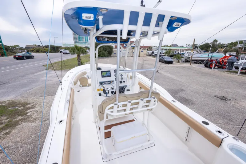 Slide: The Image of 2016 Key West 244 Center Console boat with modern helm and seating, parked near a road. - 11